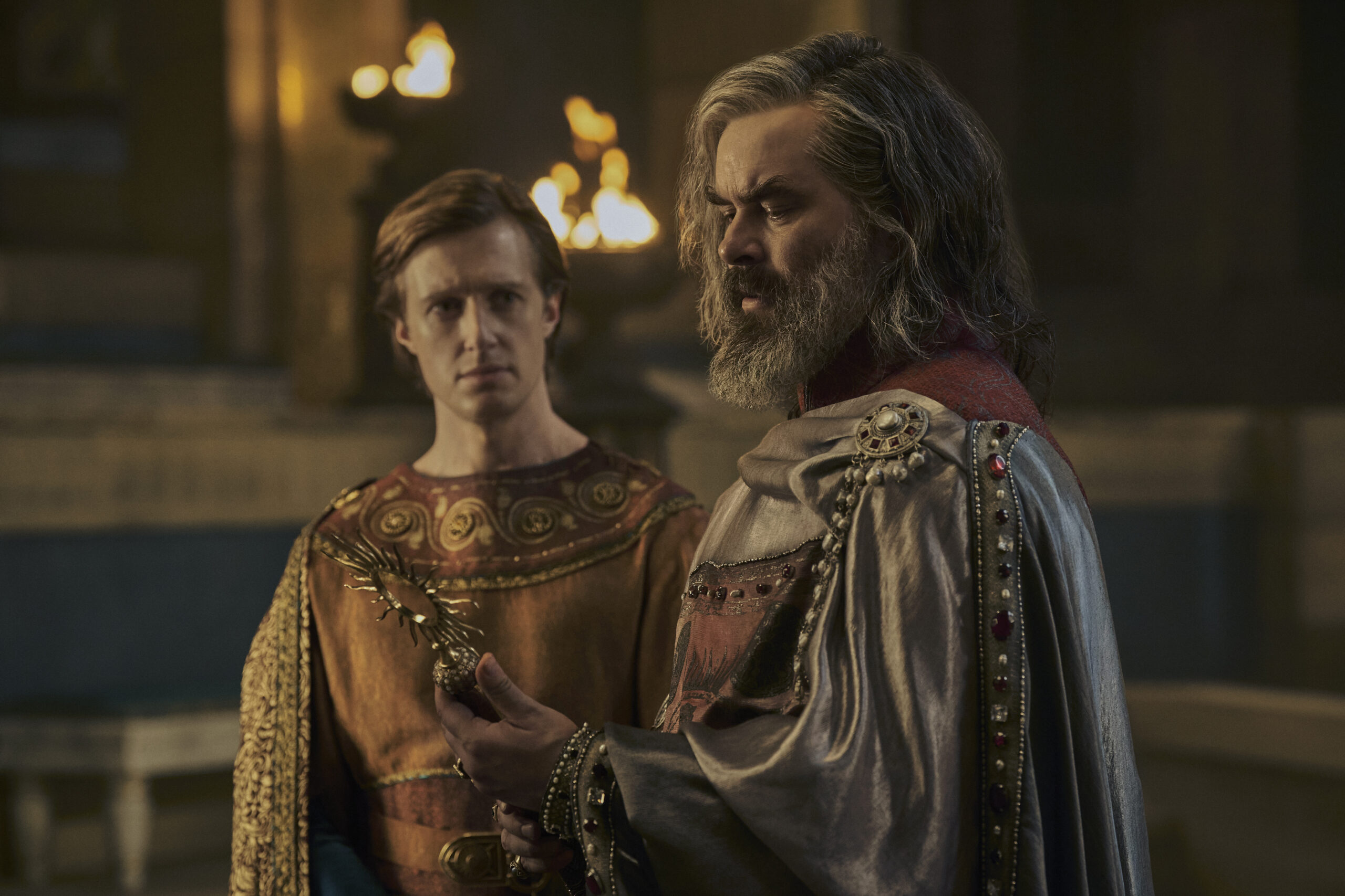 Kemen looking at his father, Ar-Pharazôn, who is looking at an ornate scepter he is holding.
