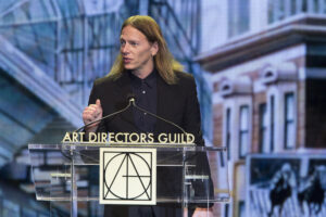James Chinlund talking at a lectern with 'Art Directors Guild' written across the front