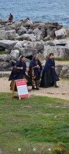 Set photo of Gil-galad, Ar-Pharazôn and Elrond in ponchos walking along a path. They do not look like the main actors