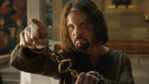 Elendil as a prisoner in handcuffs, pointing accusingly to Ar-Pharazôn off-camera