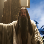 A composite image showing a shot of Ciarán Hinds as the Dark Wizard on his throne, and a portion of the painting by Ted Nasmith "The Blue Wizards Journeying East", showing the two titular wizards walking over a green hill.