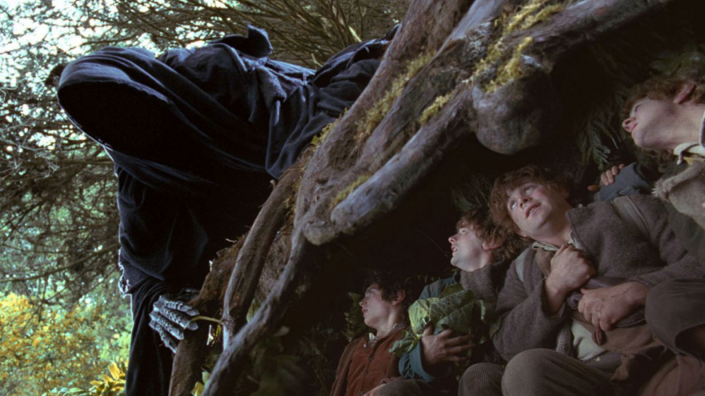 Shot of a Black Rider looming over the four hobbits Frodo, Sam, Merry and Pippin, as they hide under a tree root