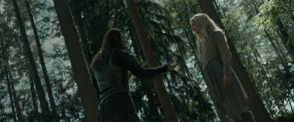 Dutch angle shot of Adar and Galadriel in a forest, as he holds out his hand towards her, palm-upward