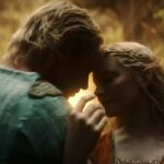 A close photo of Celeborn and Galadriel tenderly touching their foreheads together as they dance in a golden glade