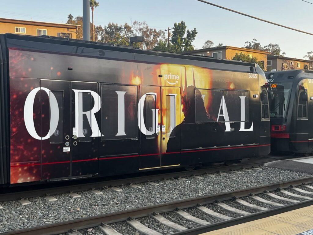 Photo of an ad on covering the whole outside a tram with the word "ORIGINAL", and the silhouette of Sauron in what is presumably the Sammath Naur in quarter profile from behind. The colour scheme is black, yellow and orange