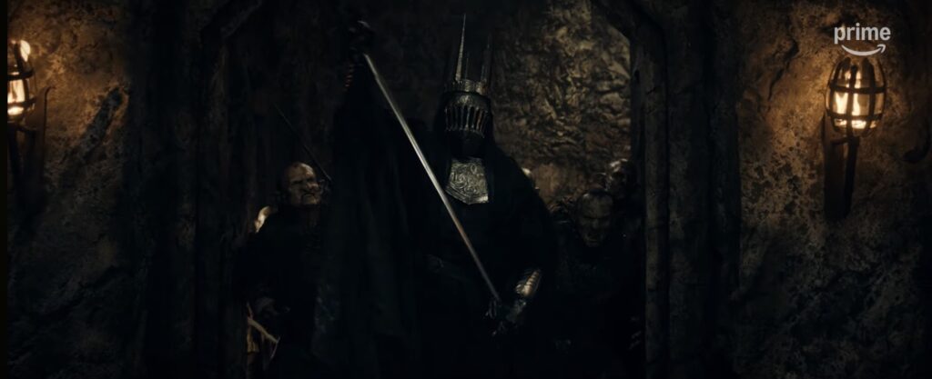 Nazgnagôl drawing a sword, accompanied by orcs, in Khazad-dûm