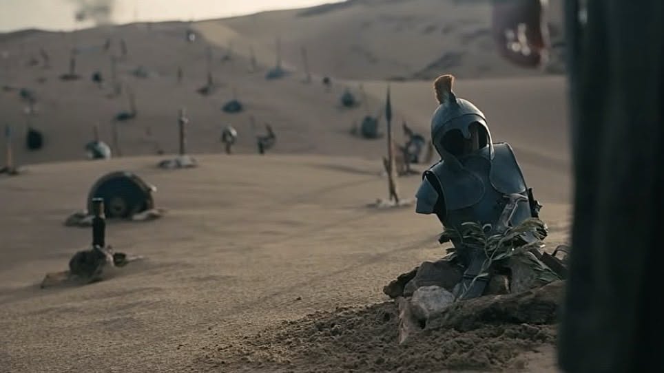 suits of armor buried in the sand stretch back to the horizon