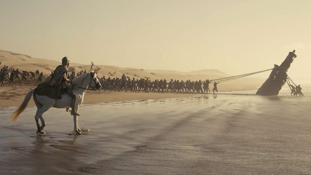 a group of people attempt to pull the Trojan Horse from the sand