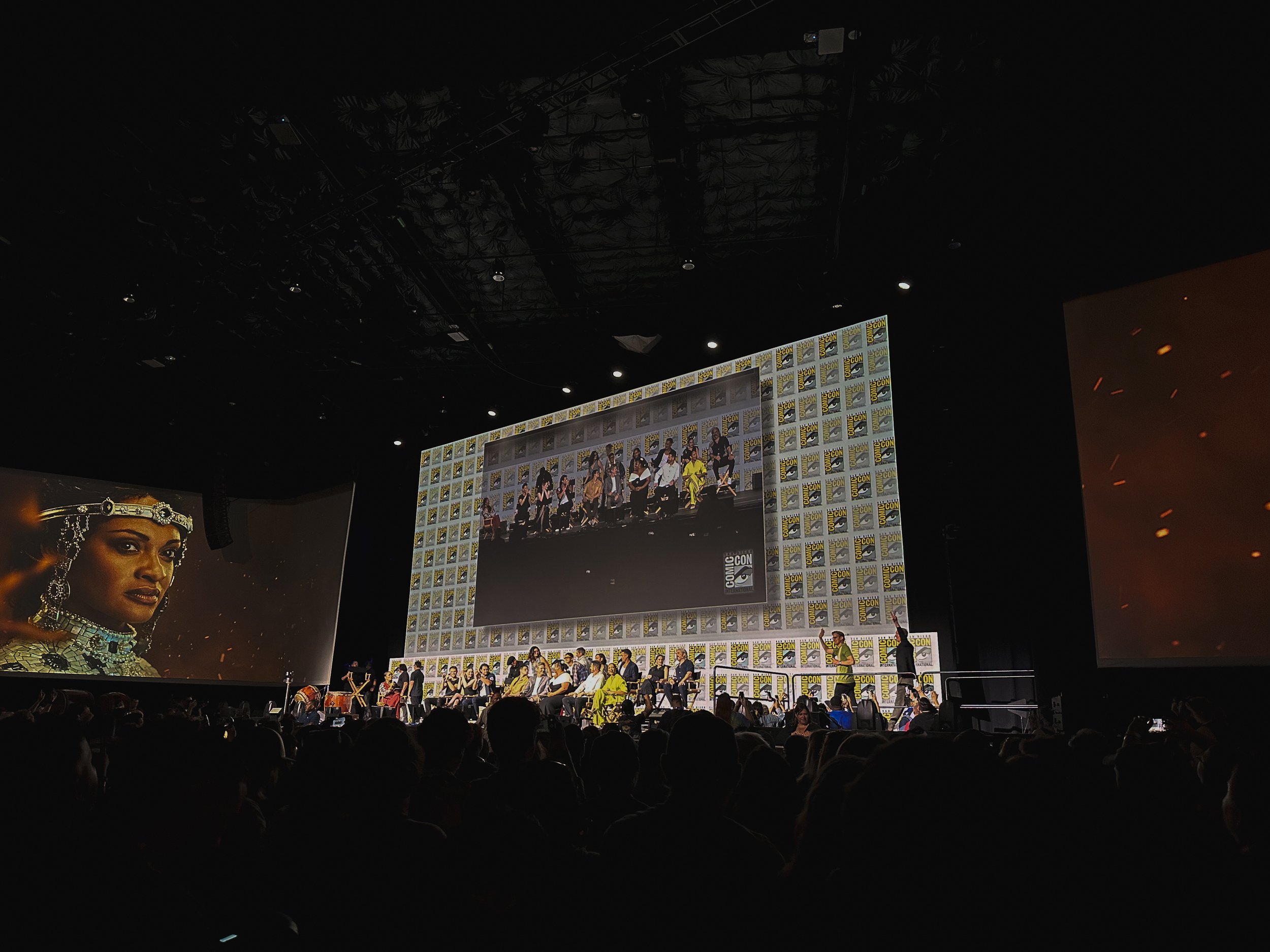 Photo of the 2024 San Diego Comic Con Rings of Power panel in Hall H, taken by Tea With Tolkien, showing the cast and showrunners arrayed on stage for the main panel