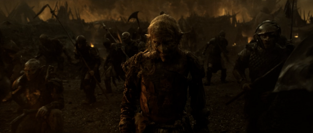 An orc marches in Mordor with a creepy smile