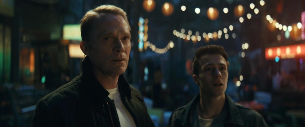 Vision and Tommy Maximoff on a dimly-lit street with shop lights behind them